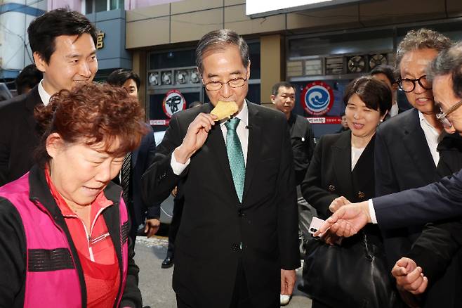 2일 오후 광주 동구 대인시장에서 한덕수 전 국무총리가 튀김을 구매한 뒤 먹고 있다. 한 전 국무총리는 이날 국회 소통관에서 기자회견을 열고 대선 출마를 공식 선언했다. 연합뉴스