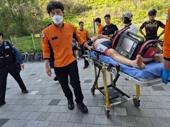 지난달 30일 서울 성동구 용비쉼터 인근에서 육군사관학교 트라이애슬론부가 응급조치한 어르신이 119 구급대에 무사히 이송되고 있다. 성동구 제공