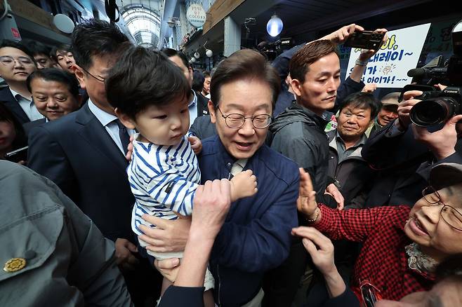 더불어민주당 이재명 대선 후보가 ‘골목골목 경청투어’ 접경지역 방문 이틀째인 5월2일 강원 철원군 동송시외버스고용터미널 인근에서 어린이를 안아주고 있다. ⓒ연합뉴스