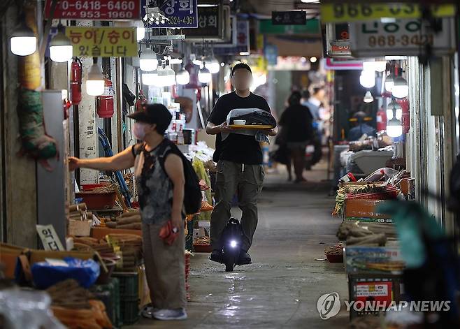 전동휠로 배달하는 식사 (서울=연합뉴스) 김도훈 기자 = 서울 지역 낮 기온이 35도를 기록하는 등 폭염이 계속되고 있는 19일 오후 서울 시내의 한 전통시장에서 한 상인이 전동휠을 타고 음식을 배달하고 있다. 2024.8.19 superdoo82@yna.co.kr