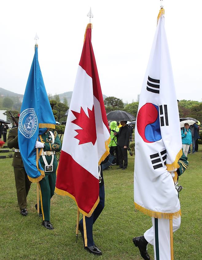 지난달 22일 오전 부산 남구 유엔기념공원 참전용사 묘역에서 캐나다 한국전 참전용사 고(故) 윌리엄 존 크라이슬러 씨의 안장식이 거행되는 가운데 (오른쪽부터) 유엔기,캐나다 국기,태극기를 든 장병들이 이동하고 있다./김동환 기자