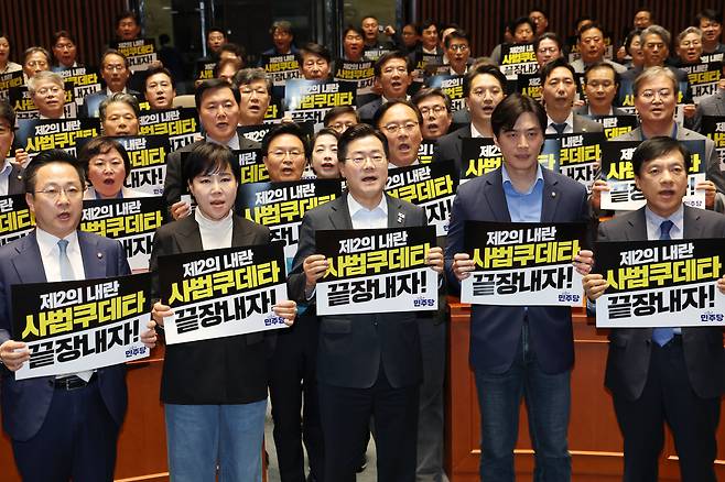 박찬대 더불어민주당 대표 직무대행 겸 원내대표와 의원들이 지난 4일 오후 서울 여의도 국회에서 열린 긴급 의원총회에서 대법원을 규탄하는 구호를 외치고 있다./뉴스1