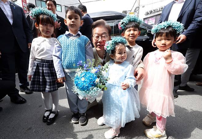 이재명 더불어민주당 대선 후보가 6일 충북 증평군 장뜰시장 입구에서 어린이들에게 꽃다발을 선물 받고 기념촬영을 하고 있다 김성룡 기자