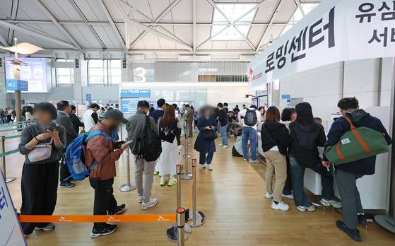 인천국제공항 제1여객터미널 출국장에 마련된 SK텔레콤 로밍센터에서 출국자들이 유심 교체를 위해 줄을 서고 있다. 연합뉴스