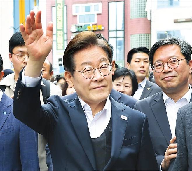 < 손 흔드는 이재명 > 이재명 더불어민주당 대선 후보가 5일 경기 양평군 양평물맑은시장에서 시민들을 향해 손을 흔들고 있다. 이 후보는 신변 위협을 이유로 시민들과 악수는 하지 않았다.  연합뉴스