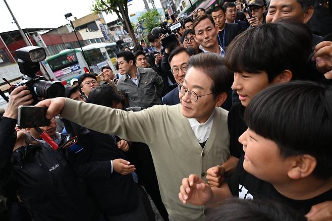 이재명 더불어민주당 대선 후보가 6일 충북 옥천군 옥천공설시장에서 시민들과 기념 촬영을 하고 있다. 성동훈 기자