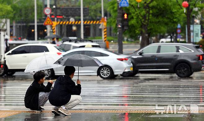[서울=뉴시스] 박주성 기자 = 서울에 비가 내리는 지난 1일 오전 서울 광화문에 학생들이 우산을 쓰고 보행신호를 기다리고 있다. 2025.05.01. park7691@newsis.com