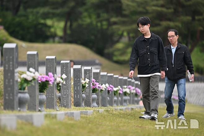 [광주=뉴시스] 이영주 기자 = 5·18민주화운동 45주기를 12일 앞둔 6일 오전 광주 북구 운정동 국립5·18민주묘지에서 한 아이가 묘지를 거닐며 5·18 희생자들의 묘비를 살피고 있다. 2025.05.06. leeyj2578@newsis.com