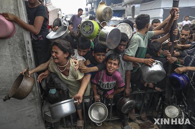 [가자시티=신화/뉴시스] 4월 24일 가자지구 가자시티의 한 급식소에서 급식을 받으려는 팔레스타인 난민들이 몰려들고 있다. 이스라엘군이 3월 2일부터 가자지구에 대한 식량 등 구호품 반입을 봉쇄한 뒤 가자지구의 인도주의적 참상이 극에 달하고 있다.  2025.04.25.