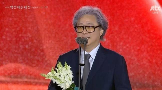박찬욱 감독이 지난 5일 서울 강남구 코엑스에서 열린 제61회 백상예술대상 시상식에서 ‘전, 란’ 시나리오를 공동 집필한 신철 작가와 함께 각본상 수상자로 지목된 뒤 수상소감을 밝히고 있다.   JTBC 캡처