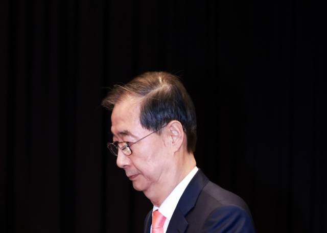 한덕수 대통령 권한대행 국무총리가 지난4월 30일 서울 여의도 중소기업중앙회에서 열린 '중소기업 규제혁신 현장 소통 간담회'에서 참석자와 기념촬영을 위해 단상으로 향하고 있다. 연합뉴스