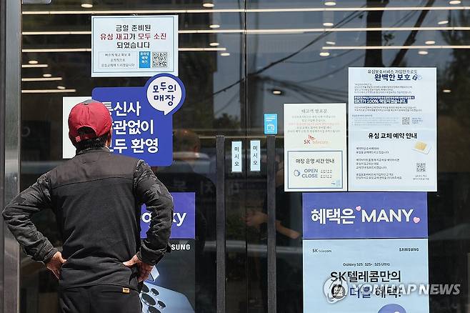 SKT 유심 해킹에 소비자는 근심 (서울=연합뉴스) 임화영 기자 = SK텔레콤이 가입자 유심(USIM) 정보 유출 사태로 오는 5일부터 신규 가입자 모집을 중단한다고 밝힌 2일 서울 시내의 한 SK텔레콤 대리점 앞에서 한 소비자가 유심 재고 소진 및 유심보호서비스 관련 안내문을 살펴보고 있다. 2025.5.2 hwayoung7@yna.co.kr
