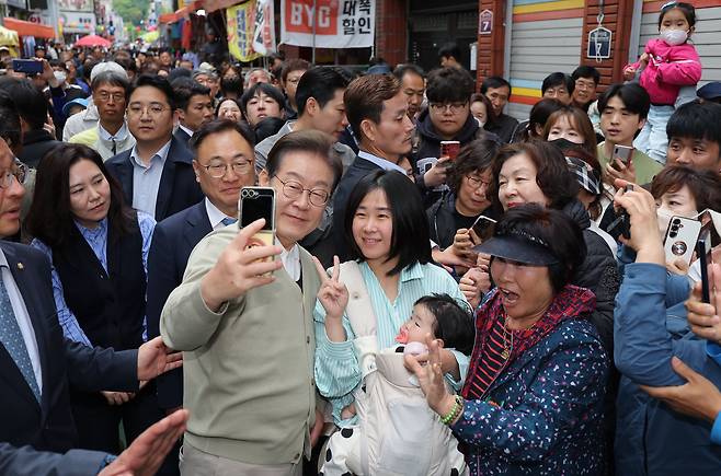 영동에서 ‘찰칵’ - 이재명 더불어민주당 대선 후보가 6일 충북 영동군 영동전통시장에서 휴대전화를 직접 들고 시민들과 ‘셀카’를 찍고 있다. /연합뉴스