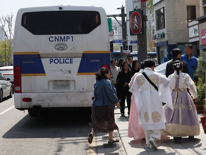 서울 종로구가 지난 10일 오후 헌법재판소 앞의 도로를 차단하고 있던 경찰버스 일부가 철수하면서 차량 통행이 가능해졌다고 11일 밝혔다. 이날 서울 종로구 헌법재판소 인근에서 외국인 관광객이 이동하고 있다. /연합뉴스