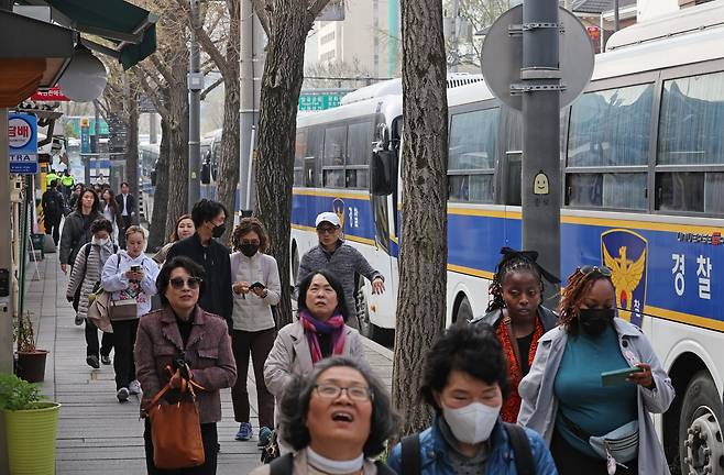 외국인 관광객들이 8일 오전 서울 종로구 헌법재판소 맞은편 보행로에서 경찰의 경비 속에 통행하고 있다./뉴시스