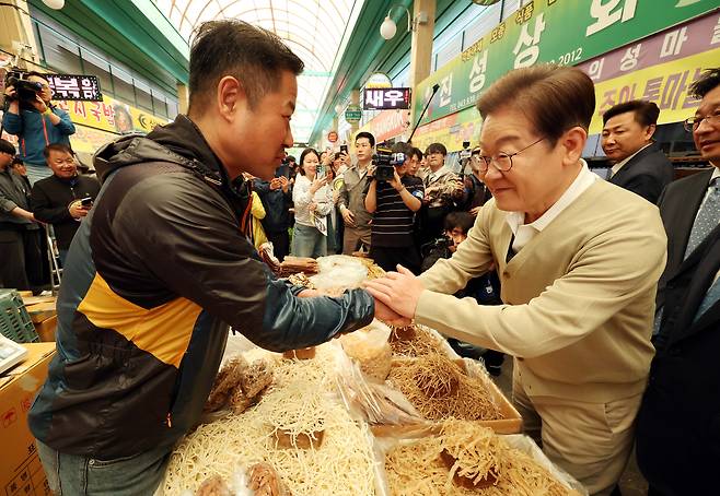 민심을 청취하는 '경청 투어'에 나선 이재명 더불어민주당 대선후보가 6일 충북 증평군 장뜰시장을 찾아 상인과 인사를 하고 있다. /뉴시스