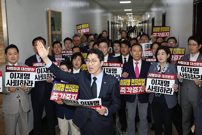 7일 서울 여의도 국회 법제사법위원회 전체회의장 앞에서 국민의힘 의원들이 '이재명 면죄입법 즉각중지' 등의 내용이 적힌 손팻말을 들고 있다./연합뉴스