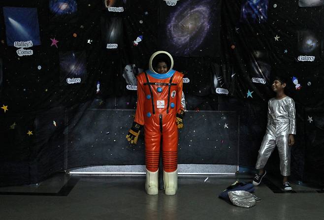 2019년 9월 18일 인도 뭄바이에서 인도우주연구기구(ISRO)와 한 대학이 주최한 우주 기술 전시회에서 학생들이 우주복을 입어보고 있다. /로이터