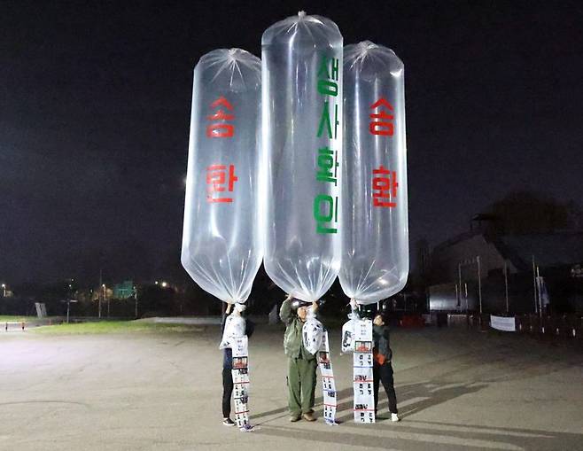 4월27일 오전 파주시 문산읍 임진각 평화랜드 펜스 뒤편에서 최성룡 납북자가족모임 대표(가운데)를 포함한 관계자들이 대북전단을 살포하고 있다. 납북자가족모임 제공