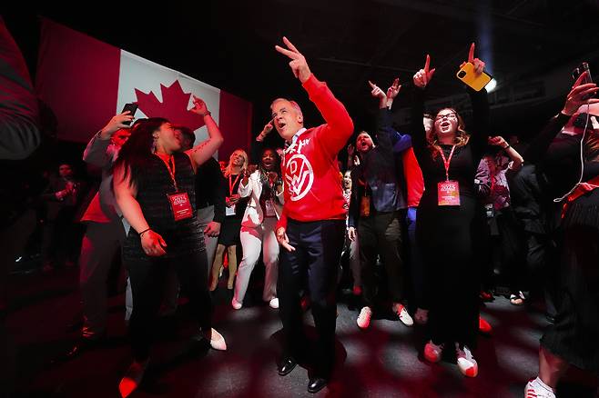 Canadian Prime Minister Mark Carney, center, dances to Canadian band Down With Webster as they play live from campaign headquarters after the Liberal Party won the Canadian election in Ottawa on Tuesday, April 29. [AP/YONHAP]