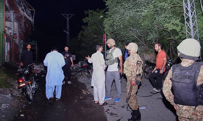 7일(현지 시간) 파키스탄령 카슈미르 무자파라바드 인근에서 취재진과 보안군 관계자들이 인도의 미사일 공격으로 추정되는 피해 현장에 모여 있다.