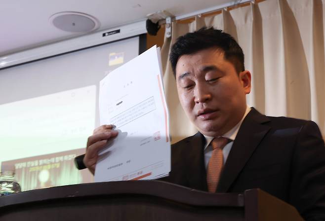 배우 김새론 유족의 법률대리인인 부지석 변호사가 7일 서울 강남구 한 공유오피스에서 기자회견을 열고 김수현에 대한 고소장을 들어 보이고 있다.   연합뉴스
