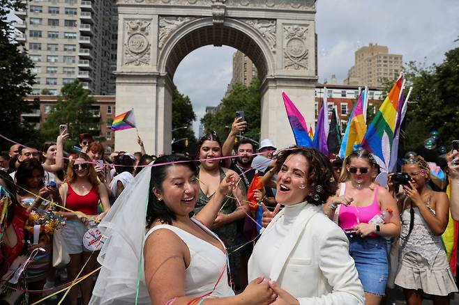 지난해 6월 미국 뉴욕 워싱턴스퀘어파크에서 열린 프라이드 행사에서 결혼을 선포한 타니아와 카밀라가 참가자들로부터 축하를 받고 있다. /로이터뉴스1