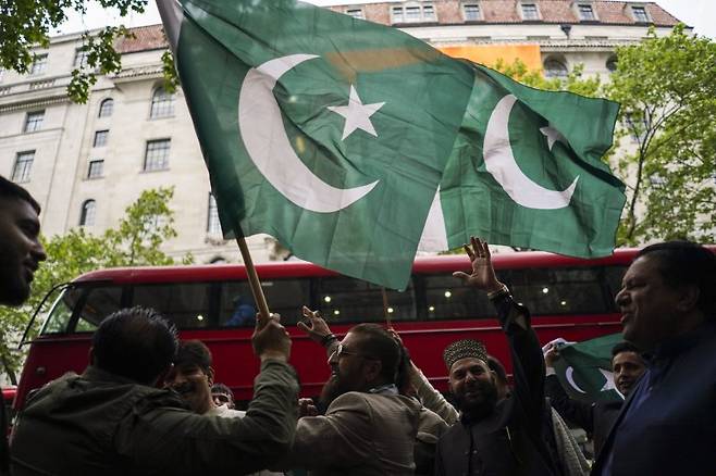 7일(현지 시간) 영국 런던에 있는 인도 고등판무관 건물 앞에서 파키스탄 국적으로 보이는 시위대가 국기를 흔들며 인도의 미사일 공격에 항의하고 있다. 뉴시스화상