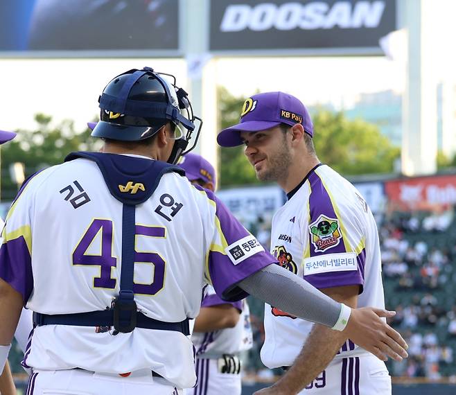 7일 잠실 LG전에서 선발 투수 잭 로그(오른쪽)와 포수 김기연. 두산 제공