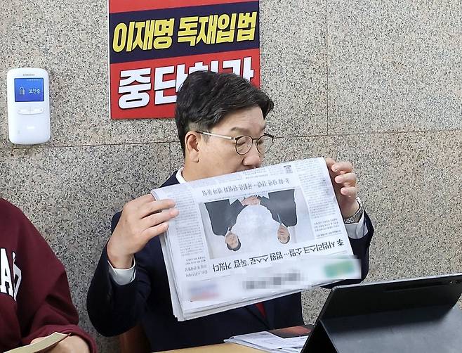 김문수 당 대선 후보를 향해 무소속 한덕수 예비후보와의 조속한 단일화를 촉구하며 단식 농성을 시작한 국민의힘 권성동 원내대표가 8일 서울 여의도 국회에서 읽고 있던 조간신문을 접고 있다.  신문 1면엔 전날 김 후보와 한 후보의 회동 모습이 실려 있다. 사진=연합뉴스