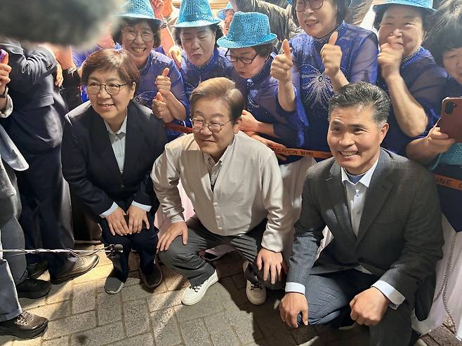 Democratic Party of Korea's presidential candidate Rep. Lee Jae-myung (center) poses for a photograph with supporters on the campaign trail in Imsil, North Jeolla Province, on Wednesday. On his left is Jeong Eun-kyeong, who served as the director of the Korea Disease Control and Prevention Agency during the COVID-19 pandemic. Kim Arin/The Korea Herald