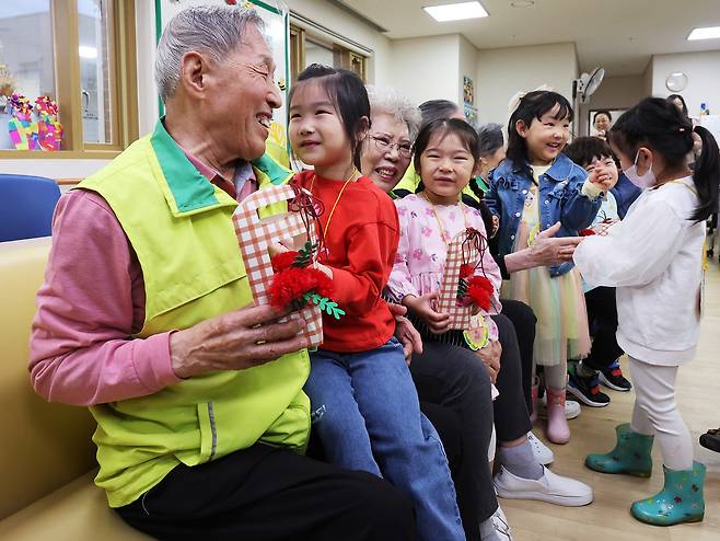 Children deliver carnations to seniors at a welfare center in Suwon, Gyeonggi, on May 7, 2024, ahead of Parents’ Day. [YONHAP]