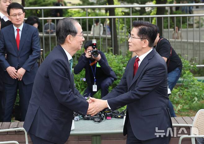[서울=뉴시스] 조성우 기자 = 김문수 국민의힘 대선 후보와 한덕수 무소속 대선 후보가 8일 서울 국회 사랑재에 위치한 커피숍에서 회동을 마친 후 악수하고 있다. 2025.05.08. photo@newsis.com