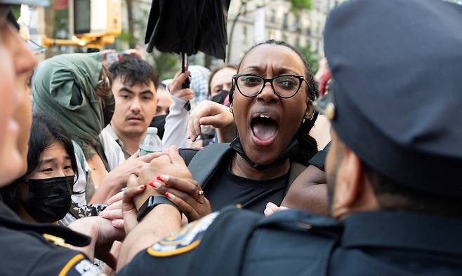 미국 뉴욕 컬럼비아대학교의 버틀러 도서관에서 팔레스타인 지지 시위대가 연행된 후 한 여성(오른쪽 두번째)이&nbsp;컬럼비아대학 캠퍼스에 출동한 경찰에 항의하고 있다. 뉴욕=로이터연합뉴스