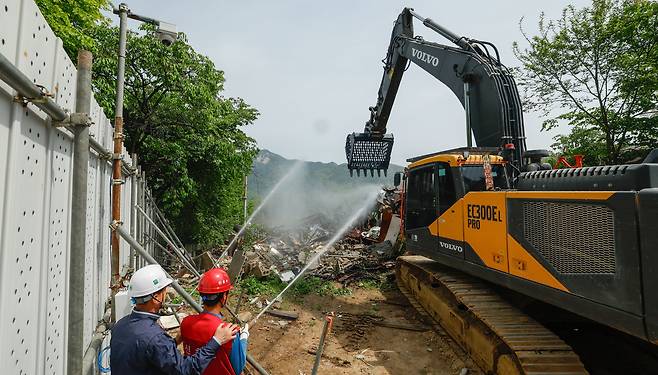 서울의 마지막 달동네인 백사마을 철거작업이 시작된 8일 서울 노원구 백사마을에서 포크레인이 담벼락을 허물고 있다.
