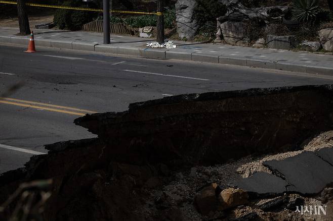 3월24일 대형 땅꺼짐 현상이 발생한 서울 강동구 명일동 한 도로의 모습. 이 사고로 희생된 이를 기리는 국화꽃이 인근에 놓여 있다.ⓒ시사IN 박미소