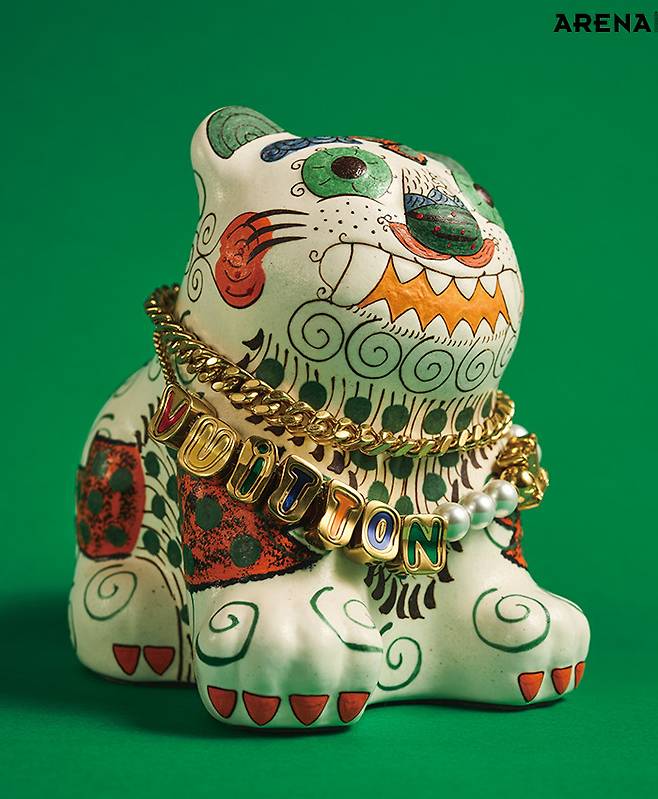 한국을 상징하는 동물인 호랑이를 밝고 유쾌하게 표현한 깜찍이호랑이 도자 인형 25만원 뮷즈 제품. 레터링을 더한 메탈 플레이트와 진주로 꾸민 더블 체인 벨트 가격미정 루이 비통 제품.