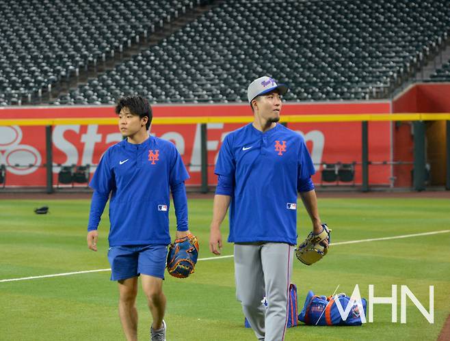 (센가(오른쪽)가 통역 히로 후지와라와 함께 운동을 끝내고 더그아웃으로 이동하고 있다)