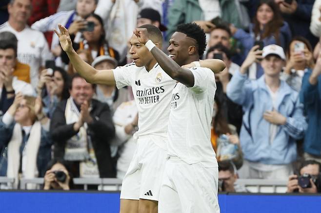 2025년 5월 4일(한국 시간), 스페인 마드리드 산티아고 베르나베우 스타디움에서 열린 라리가 레알 마드리드와 셀타 비고의 경기에서, 레알 마드리드의 킬리안 음바페(왼쪽)가 팀의 세 번째 골을 넣은 뒤 비니시우스 주니오르(오른쪽)와 함께 기뻐하고 있다.