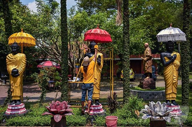 베삭 축제를 앞둔 7일(현지시간) 인도네시아 모조케르토 마하 비하라 모조파히트의 사원에서 인부들이 불상을 청소하고 있다. ⓒ AFP=뉴스1