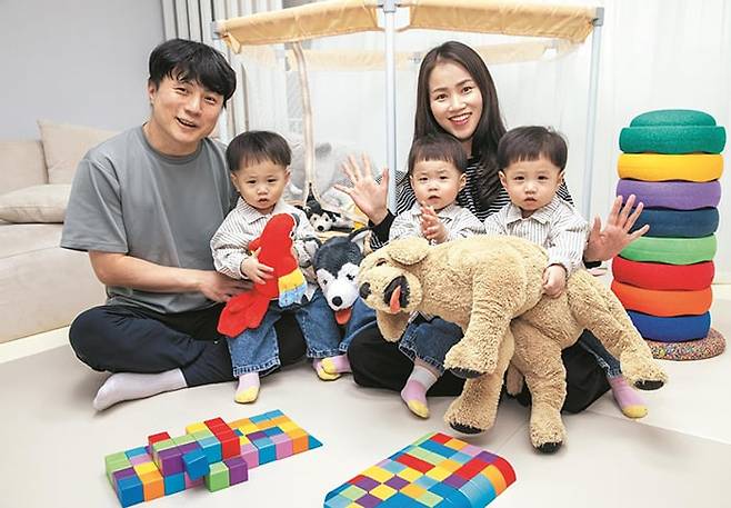 지난달 27일 서울 성북구 자택에서 이광준(뒷줄 왼쪽)·방민희씨 부부가 세 쌍둥이 아들과 함께 웃으며 손을 흔들고 있다. 앞줄 오른쪽부터 왼쪽으로 첫째 한이, 둘째 산이, 셋째 도이. /조인원 기자