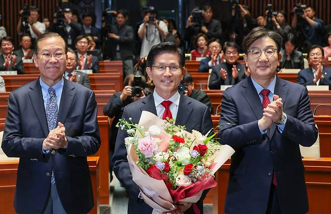 김문수 국민의힘 대통령 후보가 9일 서울 여의도 국회에서 열린 의원총회에서 꽃다발을 받은 뒤 기념 촬영하고 있다. 왼쪽부터 권영세 비대위원장, 김 후보, 권성동 원내대표. 김 후보는 지도부를 향해 "무소속을 당 후보 만들려 불법부당 수단 동원, 중단하라"며 입장을 밝힌 뒤 의총장을 떠났다./뉴스1