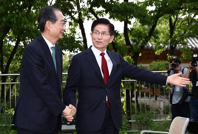 국민의힘 김문수 대선후보가 지난 8일 서울 국회 사랑재에 위치한 커피숍에서 무소속 한덕수 대선 예비후보에게 자리를 안내하고 있다. [공동취재]