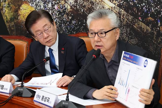 이재명 더물어민주당 대선 후보가 지난해12월 11일 국회에서 열린 비상경제점검회의에서 홍성국 더불어민주당 최고위원의 발표를 듣고 있다. 강은구 기자