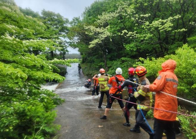 9일 제주시 조천읍 하천 범람으로 고립된 시민을 구조하는 소방대원들. 제주도 소방안전본부 제공.