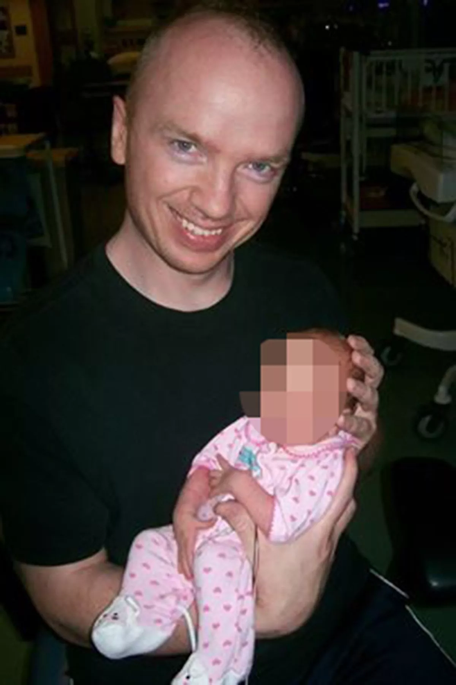 로버트 찰스 앨본이 아기를 안고 있다. [사진 = 미러]