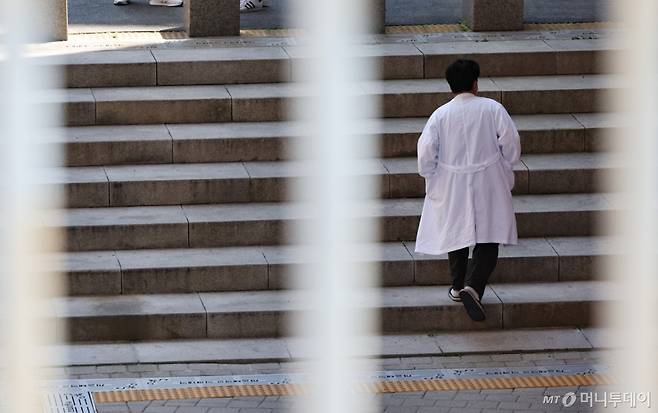 [서울=뉴시스] 황준선 기자 = 교육부와 각 의대가 제시한 미복귀 의대생에 대한 유급·제적 처분 확정일인 7일 서울 시내 한 의과대학에서 의료진이 이동하고 있다.  수업 참여 의사를 밝히지 않은 의대생들의 유급이 확정될 시 내년 학기에는 24·25·26학번이 동시에 1학년 수업을 듣는 '트리플링'(tripling) 사태가 벌어지고 의대 1학년 학생만 1만 명이 넘어 의대 교육에 차질이 생길 전망이다. 2025.05.07.  /사진=황준선