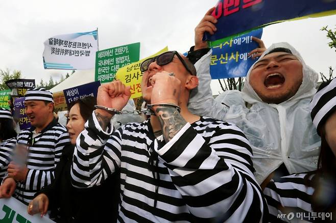 (서울=뉴스1) 황기선 기자 = 대한문신사중앙회 회원들이 9일 오후 서울 영등포구 여의도 국회 앞에서 '문신사법 제정 촉구를 위한 기자회견'을 진행하고 있다.  이날 회원들은 기자회견을 통해 문신업 종사자들의 직업적 권리 및 생존권 보장을 위한 법안 통과와 문신사 양성화를 촉구했다. 2025.5.9/뉴스1  Copyright (C) 뉴스1. All rights reserved. 무단 전재 및 재배포,  AI학습 이용 금지. /사진=(서울=뉴스1) 황기선 기자