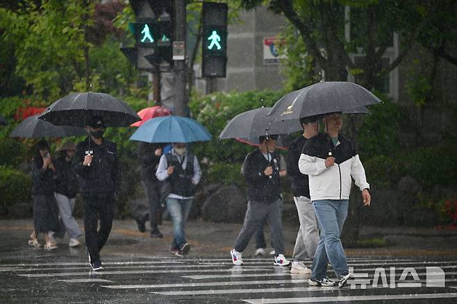 [광주=뉴시스] 이영주 기자 = 광주지역에 비가 내리는 1일 오후 광주 서구 광주시청 앞에서 시민들이 우산을 쓴 채 이동하고 있다. 2025.05.01. leeyj2578@newsis.com