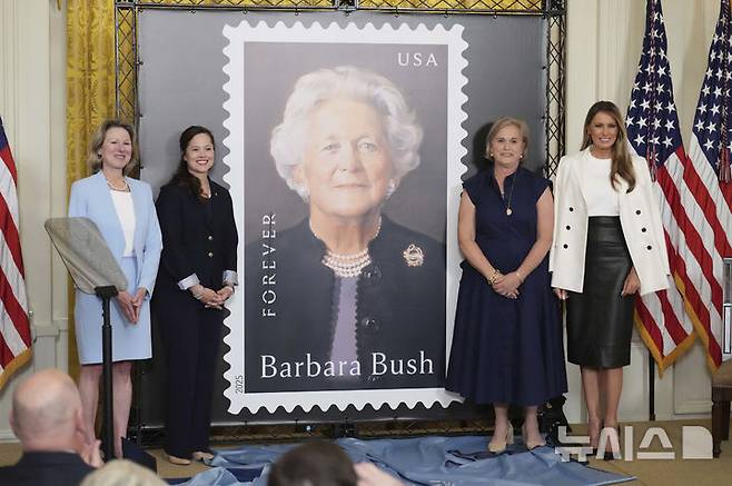[워싱턴=AP/뉴시스] 도널드 트럼프 미국 대통령 부인 멜라니아 트럼프(오른쪽) 여사가 8일(현지 시간) 백악관에서 열린 바버라 부시 여사 기념 우표 공개 행사에 참석해 참석자들과 기념촬영 하고 있다. 바버라 부시 여사는 미국의 제41대 대통령인 조지 H.W. 부시의 부인이자 제43대 대통령인 조지 W. 부시의 모친이다. 미국의 국민할머니로 불리며 문해교육, 독서장려 등 문맹 퇴치 운동에 앞장 선 인물이다. 지난 2018년 92세의 나이로 세상을 떠났다. 2025.05.09.